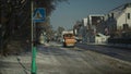 Orange machine shovels snow with bucket at fast speed from pavement and cycleway in Munich, Germany in sunny weather