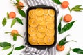 Orange-mandarin pie in baking dish on a striped linen towel