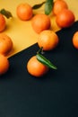 Orange mandarins clementine with green leaves on a yellow-black background Royalty Free Stock Photo