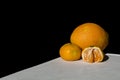 Orange and mandarins on white table with black background Royalty Free Stock Photo