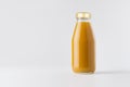 Orange mango juice in glass bottle with gold cap mock up on white background with copy space, template for packaging, advertising. Royalty Free Stock Photo