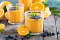 Orange and mango smoothie with granola and berries Royalty Free Stock Photo