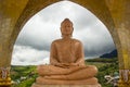 Orange marble buddha statue in meditation pose with bright sky i Royalty Free Stock Photo