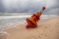 An orange marine buoy unmoored and washed up on a beach after a hurricane. Royalty Free Stock Photo