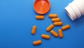 Orange medical pills and tablets spilling out of a drug bottle. Macro top Royalty Free Stock Photo