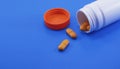 Orange medical pills and tablets spilling out of a drug bottle. Royalty Free Stock Photo