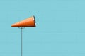 Orange megaphone making announcement against pastel blue wall Royalty Free Stock Photo