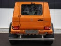 an orange mercedes g wagon is shown from the rear of the vehicle