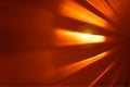 Orange metal surface with dramatic light flare background