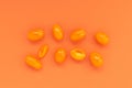 Orange mini tomatoes on orange background, monochrome concept