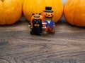 Orange miniature ceramic pumpkin guy with black cat with three orange pumpkins on the background Royalty Free Stock Photo