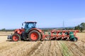 Kubota M7-173 ploughing on stubble in crop field