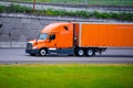 Orange modern semi truck and orange trailer on city road Royalty Free Stock Photo