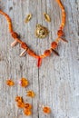 orange necklace with glass beads presented around old style wooden background. flat lay.fashion and handmade concept Royalty Free Stock Photo