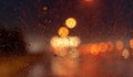 Orange night light bokeh from street light on traffic jam day. Rainy day. Transparent glass window with rain drop. Romantic weathe