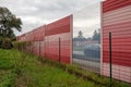 Orange noise protection wall on a freeway. Highway noise barrier