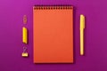 An orange notebook on a bright purple background.