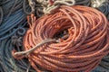 Orange Nylon rope coiled and ready for use on a working dock