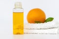 Orange oil for the body. Orange on a towel and on a white background. Organic SPA cosmetics with herbal ingredients Royalty Free Stock Photo