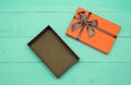 Orange opened gift box on a turquoise wooden background Royalty Free Stock Photo