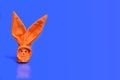 orange origami bunny on a blue background. Blank for text greeting card on the theme of Easter Royalty Free Stock Photo