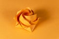 Orange origami rose on orange background