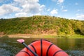 Orange packraft rubber boat with backpack on a river