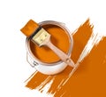Orange paint tin can with brush on top on a white background with orange strokes Royalty Free Stock Photo