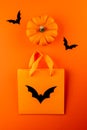 Orange paper bag, black bats and pumpkin Royalty Free Stock Photo