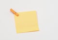 Orange paper notes fastened with a wooden clothespin on a white background Royalty Free Stock Photo