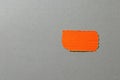 Orange paper sticker on a gray background. Space for text. Royalty Free Stock Photo