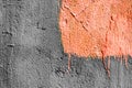 Orange pastel square with peeling paint on gray plastered wall background. Grunge texture. copy space