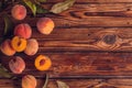 Orange peaches with green leaves on the wooden background. Sliced fruit, copy space, top view flat lay Royalty Free Stock Photo