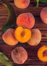 Orange peaches with green leaves on the wooden background. Sliced fruit, copy space, top view flat lay Royalty Free Stock Photo