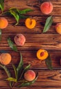 Orange peaches with green leaves on the wooden background. Sliced fruit, copy space, top view flat lay Royalty Free Stock Photo
