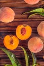 Orange peaches with green leaves on the wooden background. Sliced fruit, copy space, top view flat lay Royalty Free Stock Photo