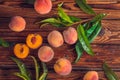 Orange peaches with green leaves on the wooden background. Sliced fruit, copy space, top view flat lay Royalty Free Stock Photo