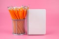 Orange pencils and notepad on a pink background with place for your text. Set of colorful pencils, copy space