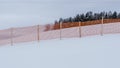 Orange perforated plastic foil barriers against snow in farmland. This protects the snow cover on agricultural fields. Royalty Free Stock Photo