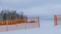 Orange perforated plastic foil barriers against snow in farmland. This protects the snow cover on agricultural fields. Royalty Free Stock Photo