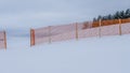 Orange perforated plastic foil barriers against snow in farmland. This protects the snow cover on agricultural fields. Royalty Free Stock Photo