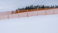 Orange perforated plastic foil barriers against snow in farmland. This protects the snow cover on agricultural fields Royalty Free Stock Photo