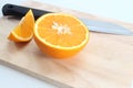 Orange pieces on a wooden board and knife