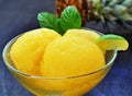 Orange pineapple sorbet scoops with lime in bowl
