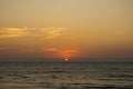 A orange pink gray sunset sky over the ocean