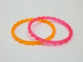 Orange and pink plastic bangles isolated on white background, beautiful fashion accessory Royalty Free Stock Photo