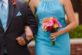 Bridesmaid and groomsman walking down the aisle with colorful bo