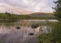 Orange pink sunset over lake Sjabatjakjaure in Parte in Sweden Lapland. Mountains, birch trees, spruce forest, rock boulders and g Royalty Free Stock Photo