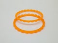 Orange plastic bangles isolated on white background, beautiful fashion accessory Royalty Free Stock Photo