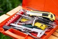 Orange plastic toolkit with instruments lies on wooden bench